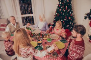 Family saying prayer before eating meal. Six relatives with clos Świąteczne zwyczaje i ciekawostki, czyli Wigilia na przestrzeni wieków